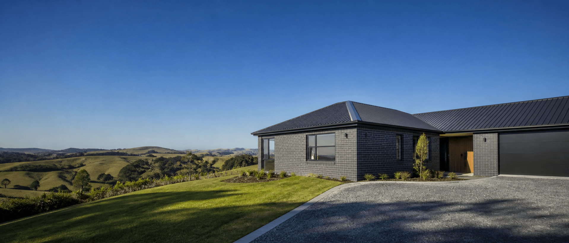 Dark brick home overlooking the Waikato landscape